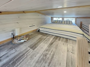 Ein kleines Schlafzimmer mit Bett, Tisch und Fenster.