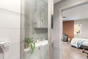 A modern bathroom with a glass shower enclosure, a white sink, and a mirror. - Victoria Court • Stay Angels (Broomhall)