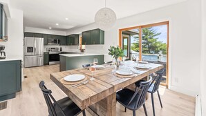 Une cuisine moderne avec des meubles de couleur vert foncé, des appareils en acier inoxydable et un grand îlot central.