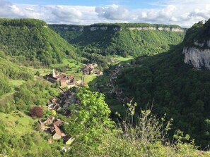 Ein Tal mit einem kleinen Dorf und einer steilen Klippe.