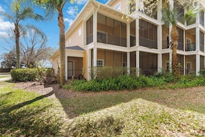 A multi-story building with balconies, surrounded by greenery and palm trees. - Updated Bahama Bay Condo | 2BR/2BA | Patio (Davenport)