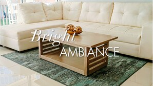 Una habitación luminosa con un sofá color beige y una mesa de centro de madera.