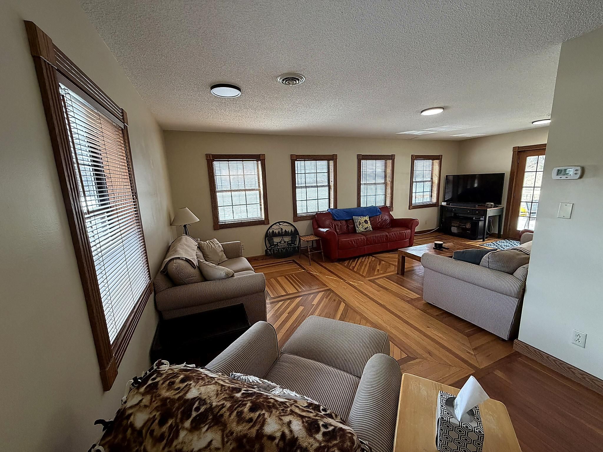 Un salón amplio con chimenea, televisor y varias zonas de estar.