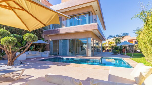 Una casa moderna con piscina, mobili da esterno e un giardino curato.