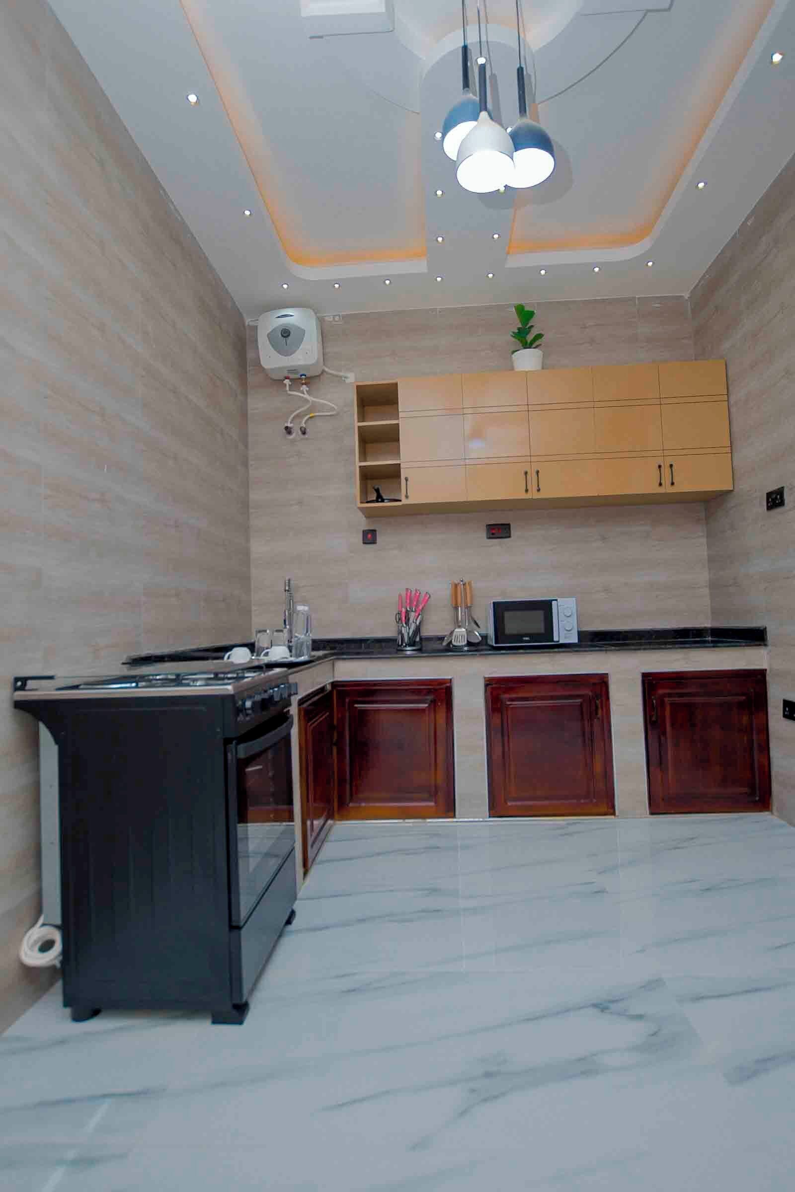 A modern kitchen with a built-in stove, a microwave, and wooden cabinets.