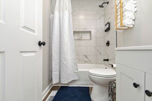 Chuveiro, toalhas de banho, sabonete, papel higiênico