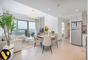 A modern apartment with a dining area, kitchen, and living space. - Vogue | Downtown with Direct Access to Dubai Mall (Dubai)