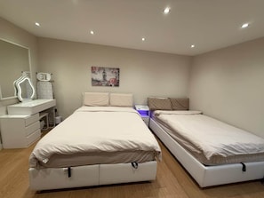 Une chambre avec deux lits, une coiffeuse avec un miroir et une table de chevet.