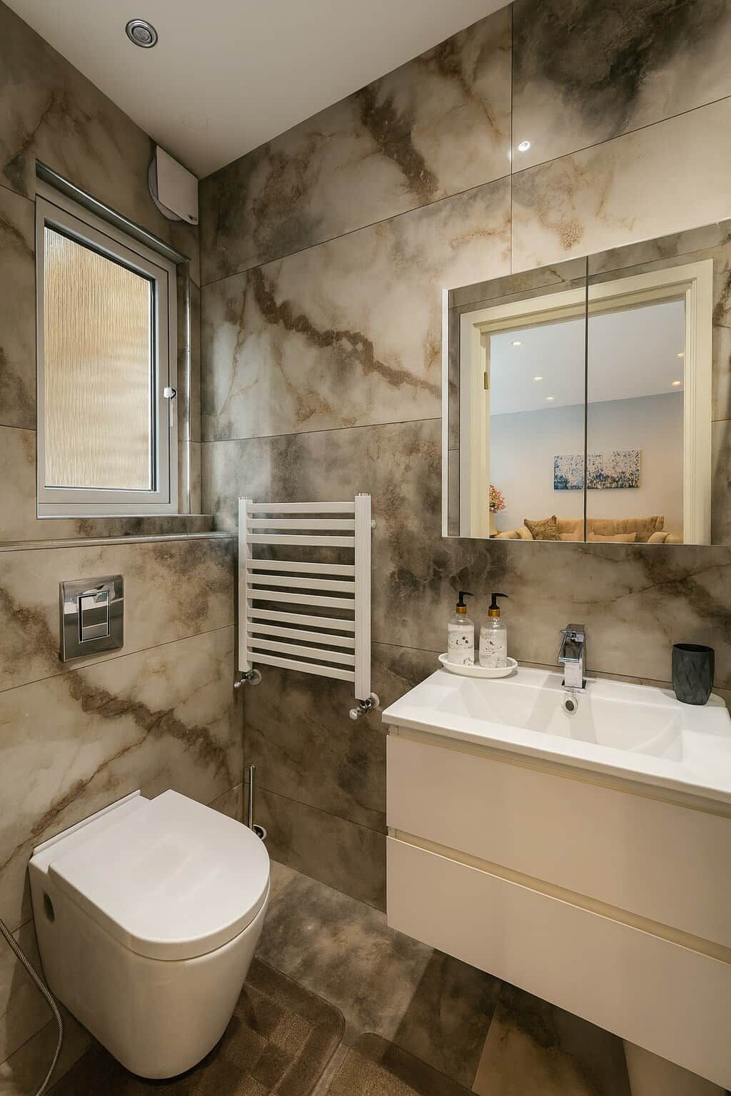 A bathroom with a white toilet, a white sink with a mirror above it, and a towel rack.