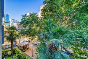 A cityscape with modern buildings, a street with cars, and lush green trees. - Thayer Home Apartment W/ Wifi near Costanera Center (Providencia)