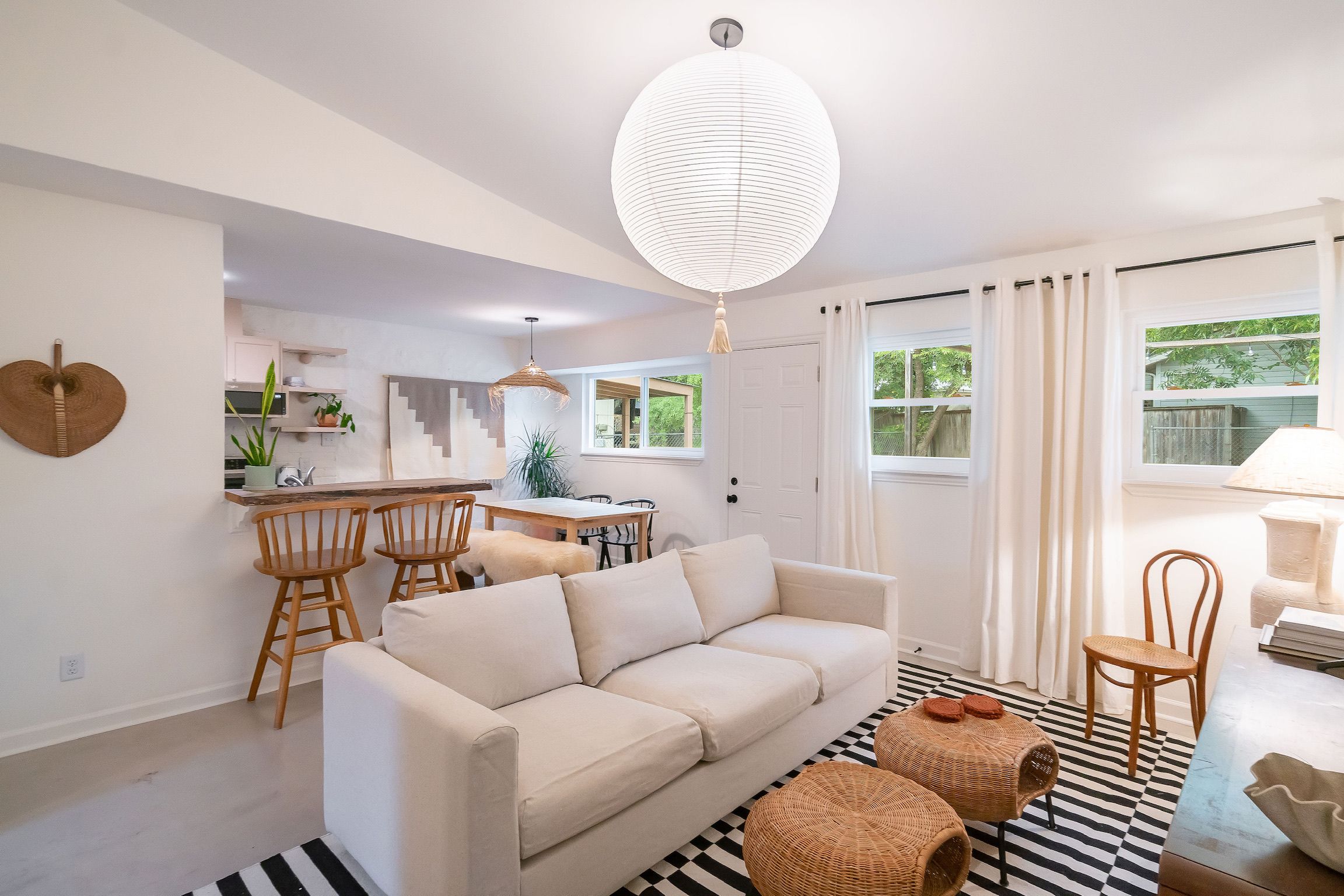 A modern living space with a sofa, dining area, and kitchen.