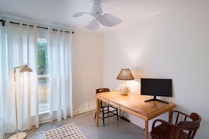 A room with a dining table, chairs, a TV, a lamp, and a ceiling fan. - 2-bedroom house in Pet-Friendly E. Austin Home  - Close to downtown & Airport (Austin)
