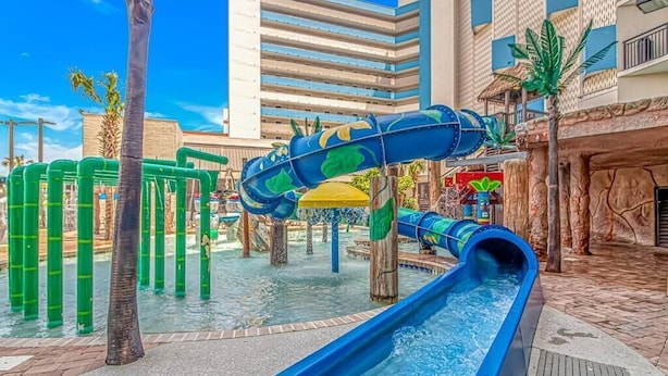Een waterpark met glijbanen en palmbomen.