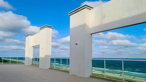Un edificio moderno con grandes ventanales que dan a una playa.