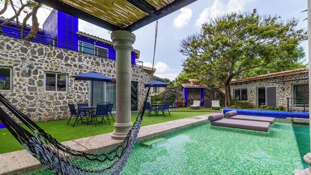A swimming pool with a hammock, stone walls, and blue accents. - Escape to the countryside: Private House in Boutique Complex. (Tepoztlán)