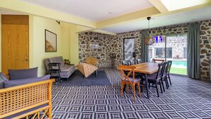 A room with a patterned floor, a dining table with chairs, a sofa, and a wicker chair. - Escape to the countryside: Private House in Boutique Complex. (Tepoztlán)