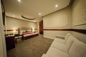 A hotel room with a bed, a desk, a chair, and a sofa. - 49 Park Villa (Belgrade)