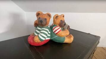 Dos ositos de peluche sentados sobre una maleta negra.