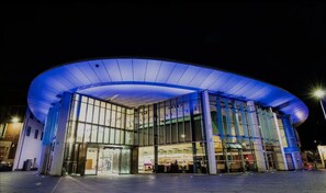 A modern building with a curved glass facade and a blue-lit entrance. - Perth city centre accommodation,2 minutes to the concert hall  and museum (Perth)