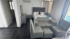 Una stanza moderna e luminosa, con un divano, un tavolo da pranzo e una ventola a soffitto.