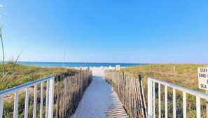 A sandy pathway leading to the beach with a sign that reads "STAY SAND & SEA." - Snowbird Rate Beachfront Complex Studio Sleeps 2! (Orange Beach)