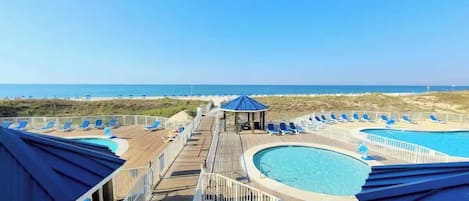 A pool area with multiple swimming pools, lounge chairs, and a gazebo.