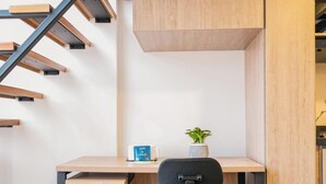 A modern office space with a desk, chair, coffee cup, and a small plant. - Tribeca Park by Jalo (Bogotá)