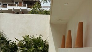 A child crawling on a white outdoor sofa near a pool, with a white wall and plants in the background. - Taormina Starlink House -10 guests, AC, Safe Neighborhood (La Barra de Colotepec)