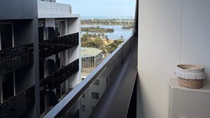 Un balcón con vista a un edificio moderno y una masa de agua.