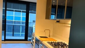 Una cocina moderna con un ventanal grande, una estufa a gas y un lavavajillas.