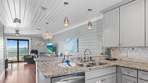 A modern kitchen with granite countertops, stainless steel appliances, and a view to the outside. - Costa Vista Townhouse #13 (Miramar Beach)