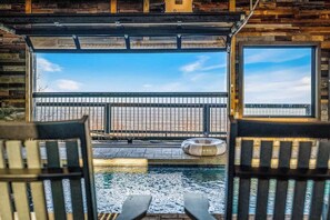 A pool area with a view of a distant landscape, two lounge chairs, and a circular floating object. - 5-Bedroom Cabin with Indoor Pool, Pickleball Court & Hot Tub Near Dollywood (Sevierville)