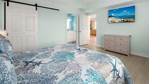 A bedroom with a bed, a dresser, and a painting of a beach scene. - Newly Constructed Condo in the Heart of Ocean City (Ocean City)