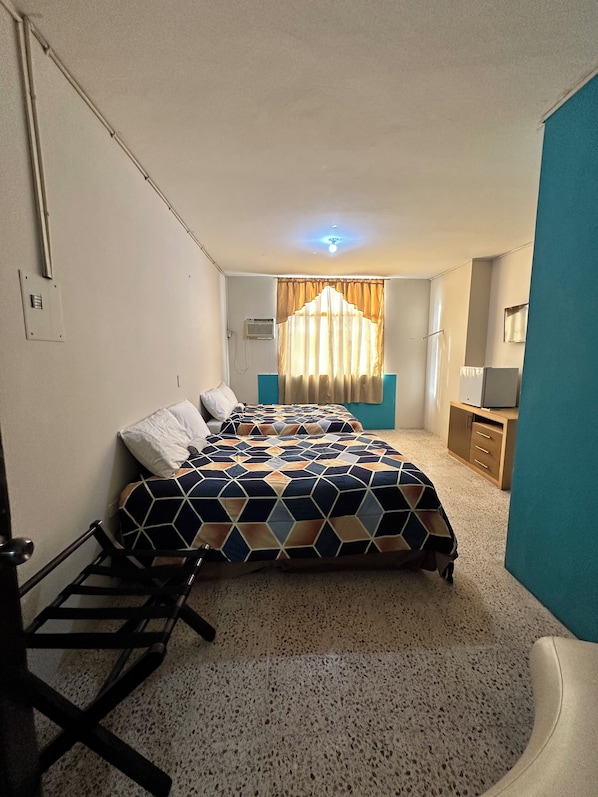 A bedroom with a bed, a desk, a chair, a wardrobe, and a window with curtains. - Hotel Oro Mar (Manta)