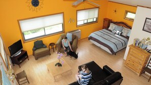A spacious living room with a large bed, a sofa, and a television.