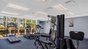 A gym with treadmills, weight machines, and a bench. - Unique Disney & Lake view- 1BD condo (Orlando)