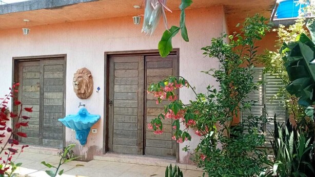 Ein Gebäude mit zwei Holztüren, einer Löwenstatue und einem blauen Brunnen.
