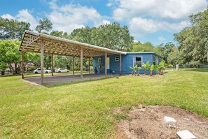 A blue house with a covered porch and a grassy yard.
