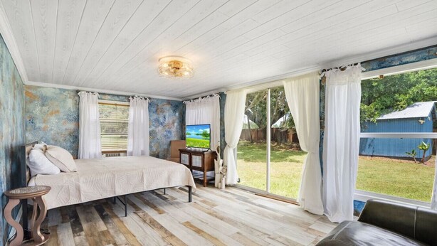 Une chambre avec un lit, une télévision et une vue sur l’extérieur.
