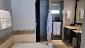 Ein modernes Badezimmer mit einer großen Badewanne, einem Waschtisch und einer Duschkabine.