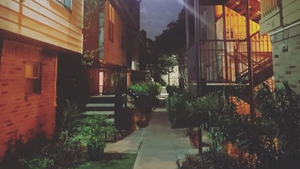 A narrow alleyway between buildings with a clear sky and a visible moon. - Lovely South Austin Condo. All Essentials Included (Austin)