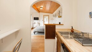 A compact kitchen with a wooden countertop, a sink, and a dish rack. - East Austin Garden Cottage |  Sweet & Private (Austin)