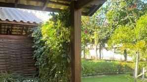 An outdoor dining area with a table set for breakfast, surrounded by greenery and a tiled floor. - Pousada Rancho Paraiso (Porto de Pedras)