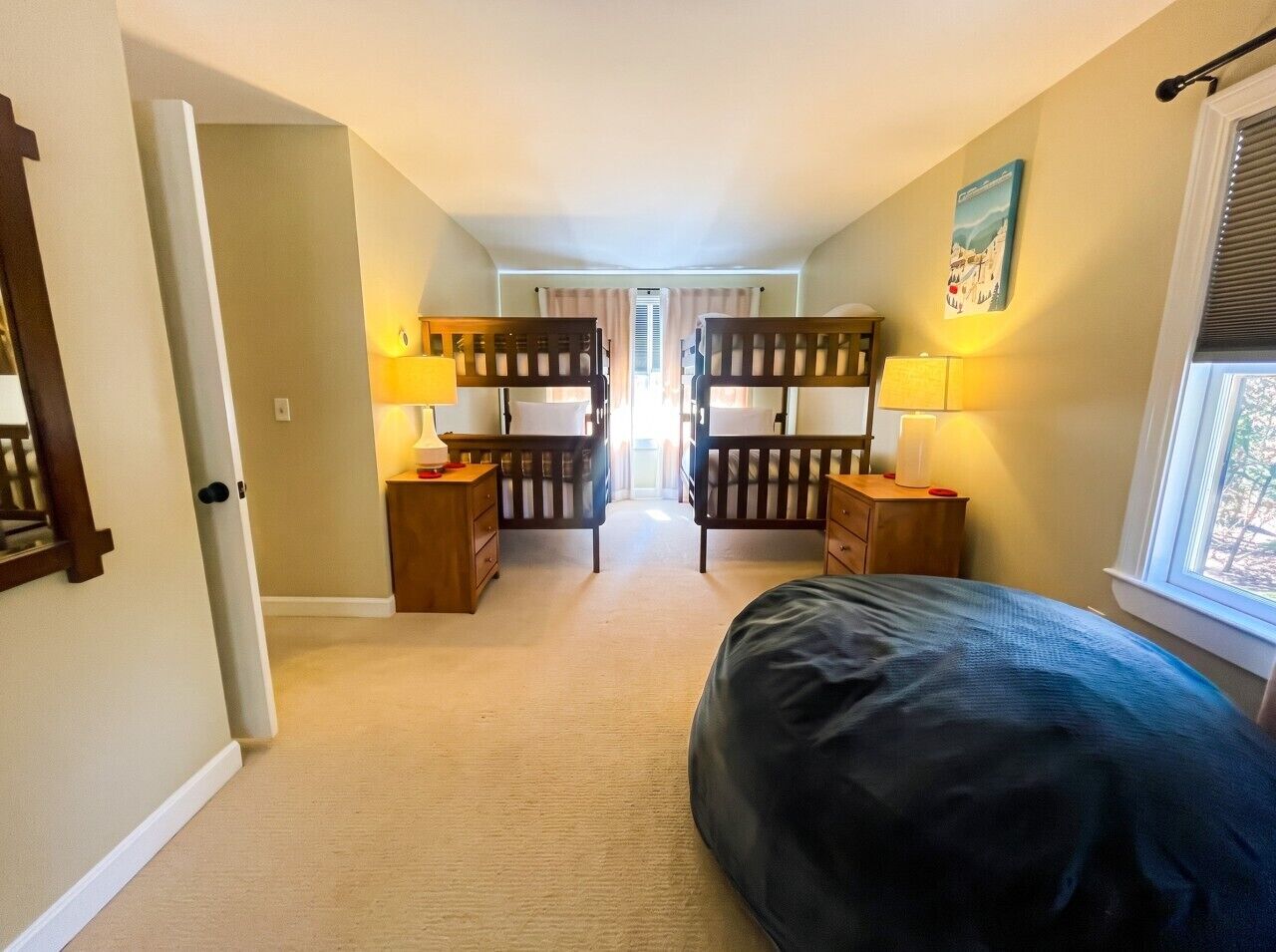 Une chambre à coucher avec un lit, deux tables de chevet, une commode et une fenêtre.
