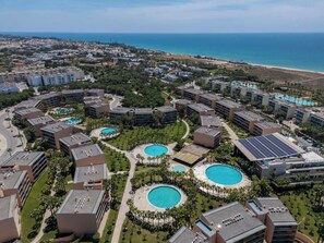 Un complex turístic amb diverses piscines, una platja i vista a l'oceà.