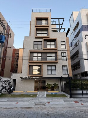 A modern multi-story building with a storefront labeled "AUREA Bauten." - Flat Cabo Branco Aurea 50m do mar 601 (João Pessoa)