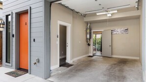 A modern building with a concrete floor, a door marked 'A', and a hallway leading to another room. - Modern Midtown Oasis: Mountain Views & Walkable Vibes (Reno)