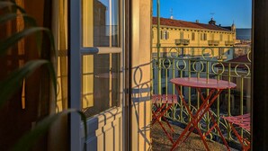 Ein Balkon mit Blick auf Gebäude und einen klaren Himmel.