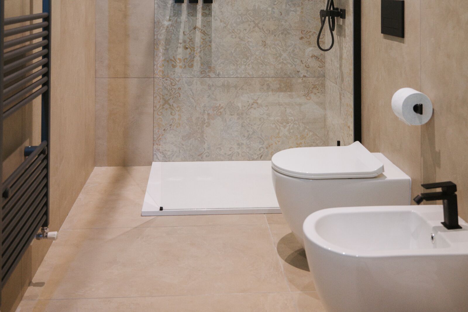Een moderne badkamer met douchecabine, toilet en bidet.