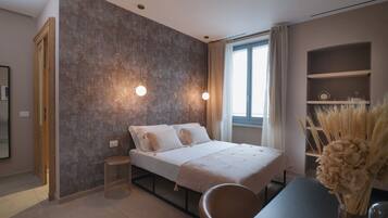 A modern bedroom with a bed, bedside tables, a window, and a bookshelf.